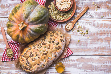 Image showing White bread with pumpkin seeds on wooden table in rustic style