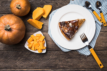 Image showing Tasty pie on plate and pieces of pumpkin in Rustic style