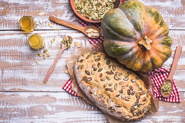 Image showing Bread with seeds and pumpkin on wooden table in rustic style