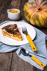 Image showing Pumpkin pie piece with cream soup on wood in Rustic style