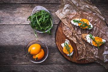 Image showing Bruschetta with tomatoes and rucola on board in rustic style