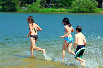Image showing Children running into water