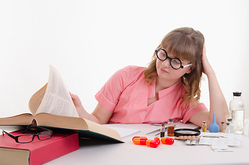 Image showing Tired student pharmacist flipping book