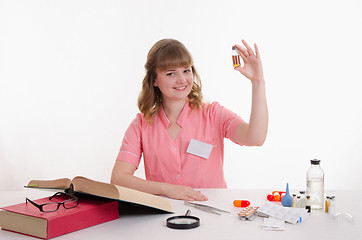 Image showing Pharmacist sitting at a table with an ampoule