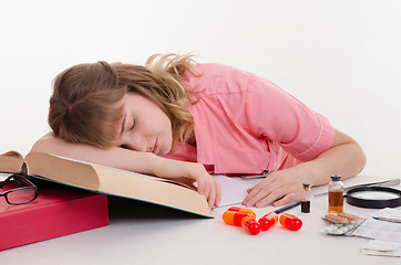Image showing Tired pharmacist sleeping on the reference