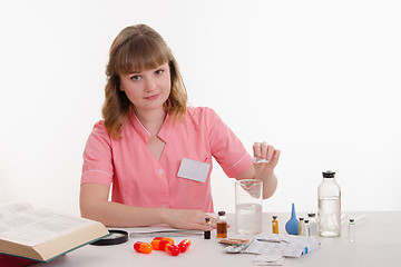 Image showing Pours pharmacist prepares the medication