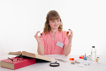 Image showing Pharmacist considers two liquid in the vial