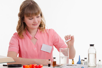 Image showing Pharmacy pours white powder with a liquid in flask