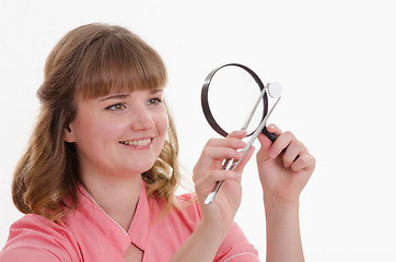 Image showing Pharmacist closely examines tablet under a magnifying glass