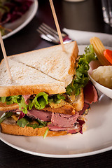 Image showing Delicious pastrami club sandwich and pickles