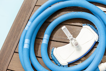 Image showing Brush and Leaf Skimmer Beside Swimming Pool