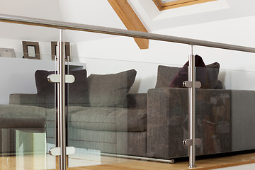 Image showing Grey Sofa Behind Metal and Glass Railing