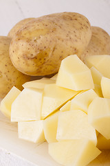 Image showing Whole Potatoes and Chopped Pieces on Cutting Board