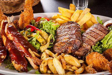 Image showing Platter of mixed meats, salad and French fries