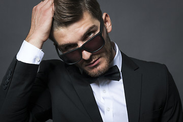 Image showing Handsome businessman adjusting his tie