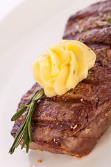 Image showing Grilled beef steak topped with butter and rosemary