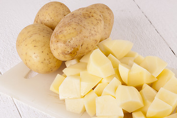 Image showing Whole Potatoes and Chopped Pieces on Cutting Board