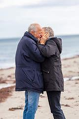 Image showing happy elderly senior couple walking on beach