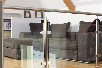 Image showing Grey Sofa Behind Metal and Glass Railing