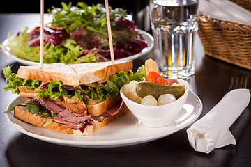 Image showing Delicious pastrami club sandwich and pickles