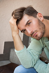 Image showing Casual  young man sitting on steps