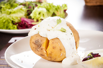 Image showing Baked jacket potato with sour cream sauce