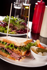 Image showing Delicious pastrami club sandwich and pickles