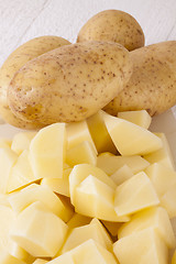 Image showing Whole Potatoes and Chopped Pieces on Cutting Board