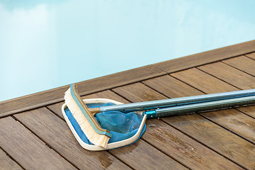 Image showing Brush and Leaf Skimmer Beside Swimming Pool