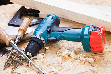 Image showing Drill with timber, screwdrivers and screws