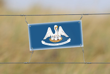 Image showing Border fence - Old plastic sign with a flag