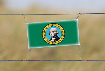 Image showing Border fence - Old plastic sign with a flag