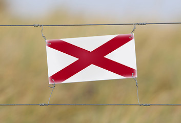 Image showing Border fence - Old plastic sign with a flag