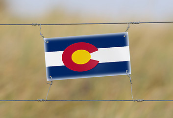 Image showing Border fence - Old plastic sign with a flag