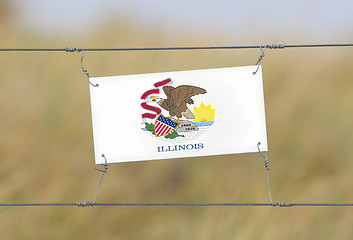 Image showing Border fence - Old plastic sign with a flag