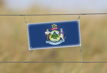 Image showing Border fence - Old plastic sign with a flag