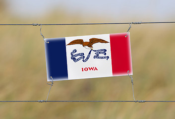 Image showing Border fence - Old plastic sign with a flag