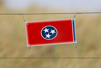 Image showing Border fence - Old plastic sign with a flag