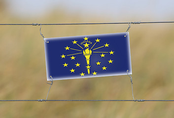 Image showing Border fence - Old plastic sign with a flag