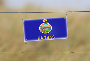 Image showing Border fence - Old plastic sign with a flag