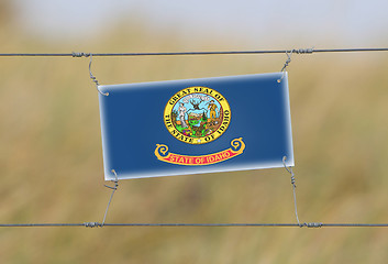 Image showing Border fence - Old plastic sign with a flag