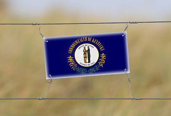 Image showing Border fence - Old plastic sign with a flag