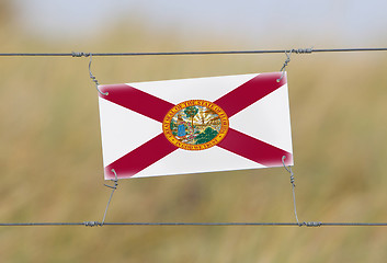 Image showing Border fence - Old plastic sign with a flag