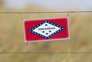 Image showing Border fence - Old plastic sign with a flag