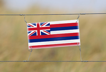 Image showing Border fence - Old plastic sign with a flag