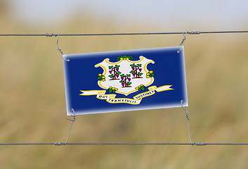 Image showing Border fence - Old plastic sign with a flag