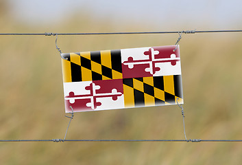 Image showing Border fence - Old plastic sign with a flag