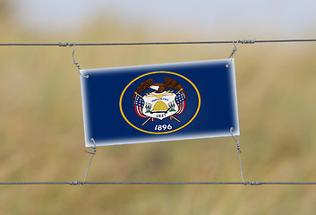 Image showing Border fence - Old plastic sign with a flag