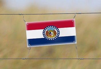 Image showing Border fence - Old plastic sign with a flag