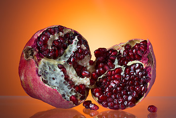 Image showing Ripe red pomegranate, break in half, juicy corn